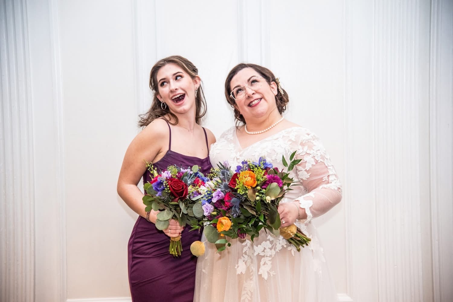 Bride and bridesmaid with colorful floral bouquets